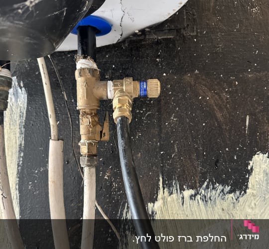צנרת ומחברים של דוד שמש על קיר שחור